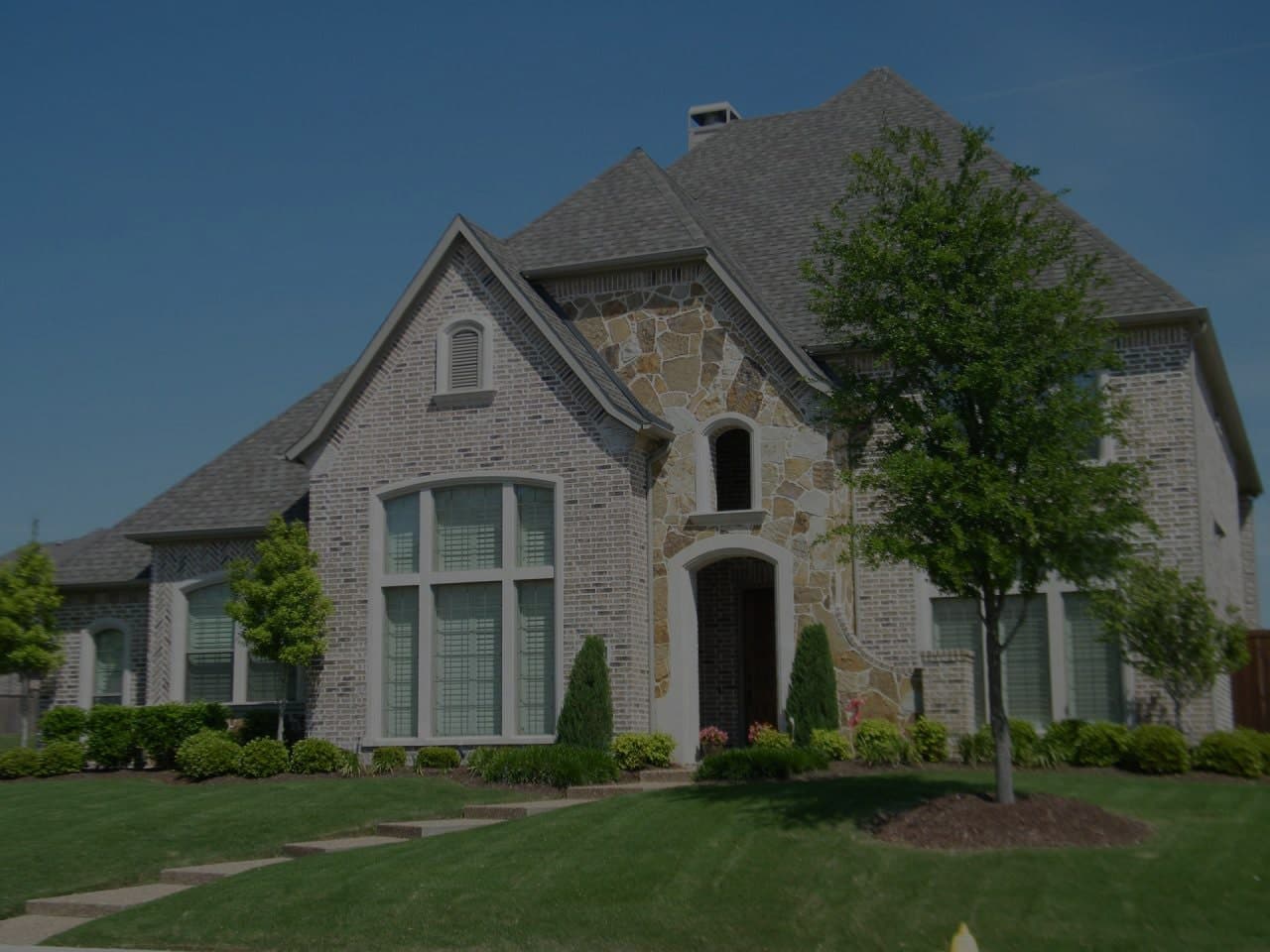 Stone brick house with a freshly cut lawn, showcasing a well-maintained exterior and pristine landscaping, ideal for buyers looking for a move-in ready property with excellent curb appeal